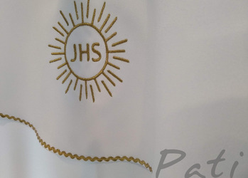 Hostia wyhaftowana złotą nitką.